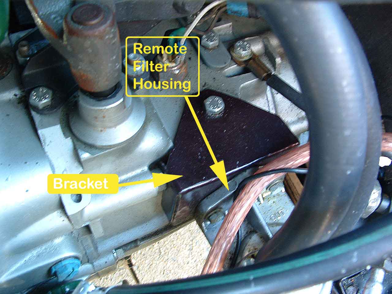 Closeup of the bracket created to mount the oil filter housing on a CX with the Douvrin engine. Note the ear for the transmission bolt, just under the yellow arrow.